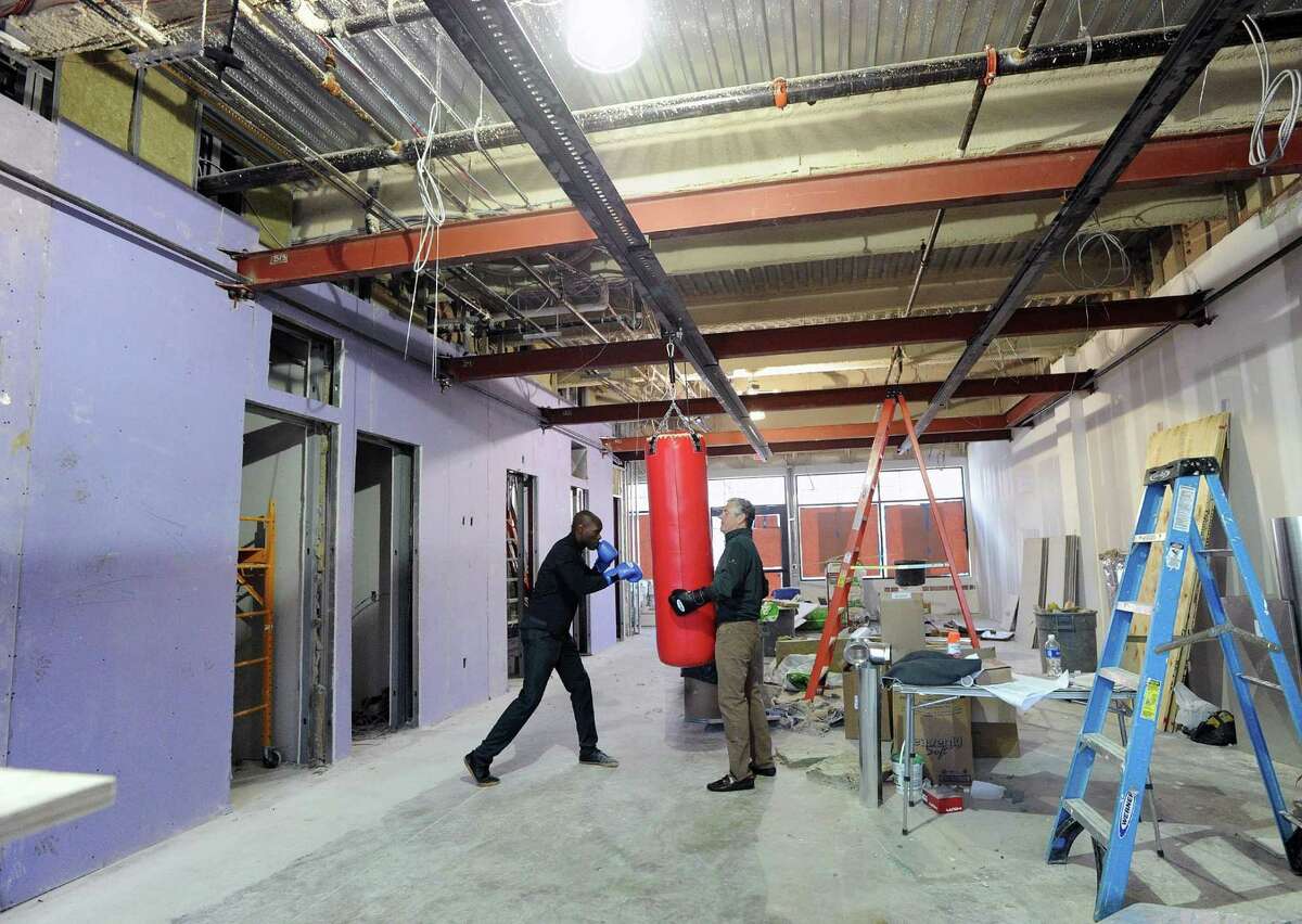 At left, Jonathan Edmond a co-owner of Belly and Body, a new independent boxing gym, works out on a punching bag as co-owner Jim Perry holds the bag in their gym that is under construction in Greenwich, Conn., Thursday, April 13, 2017. Edmond and Perry said their gym will be opening by the end of May.