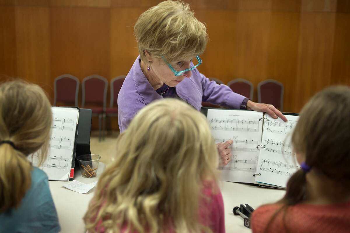 Prime Chimers director Connie Nicholson, center, points out different notes to from left: 7-year-old Alexis Wilson, 8-year-old Alexa Warren and 9-year-old Katelyn Cassiday during a practice at United Methodist Church Wednesday afternoon. The Prime Chimers are practicing for the 40th Handbell Concert at the church April 23 at 7 p.m. The concert will feature songs from four handbell groups and is free to the public. The Prime Chimers will play "Siyahamba" and "It's a small world" at the concert.
