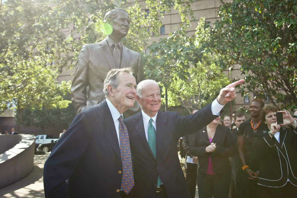 Former Secretary of State James Baker III (right) and former President George H. W. Bush point to a statue across Buffalo Bayou of President Bush as they stand in front of the newly unveiled James A. Baker Monument during a dedication ceremony. A native Houstonian, Baker, served as the 61st Secretary of State. ( Michael Paulsen / Houston Chronicle )