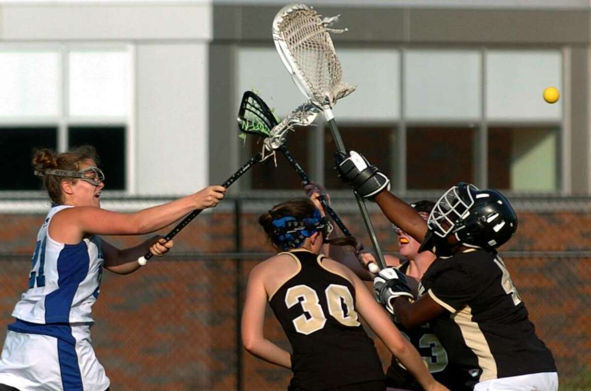 Fairfield Ludlowe's #21 Tierney Larson, left, slings the ball past Trumbull goalie Janae Burton, during CIAC first round lacrosse action in Fairfield, Conn. on Thursday June 03, 2010.