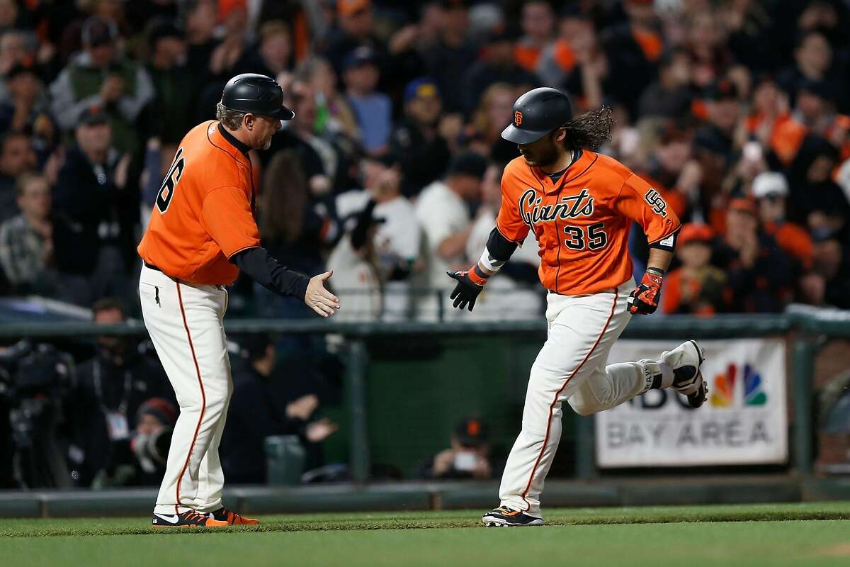 SAN FRANCISCO, CA - APRIL 14: Brandon Crawford #35 of the San Francisco Giants celebrates with third base coach Phil Nevin #16 after hitting a home run in the fourth inning against the Colorado Rockies at AT&T Park on April 14, 2017 in San Francisco, California. (Photo by Lachlan Cunningham/Getty Images)