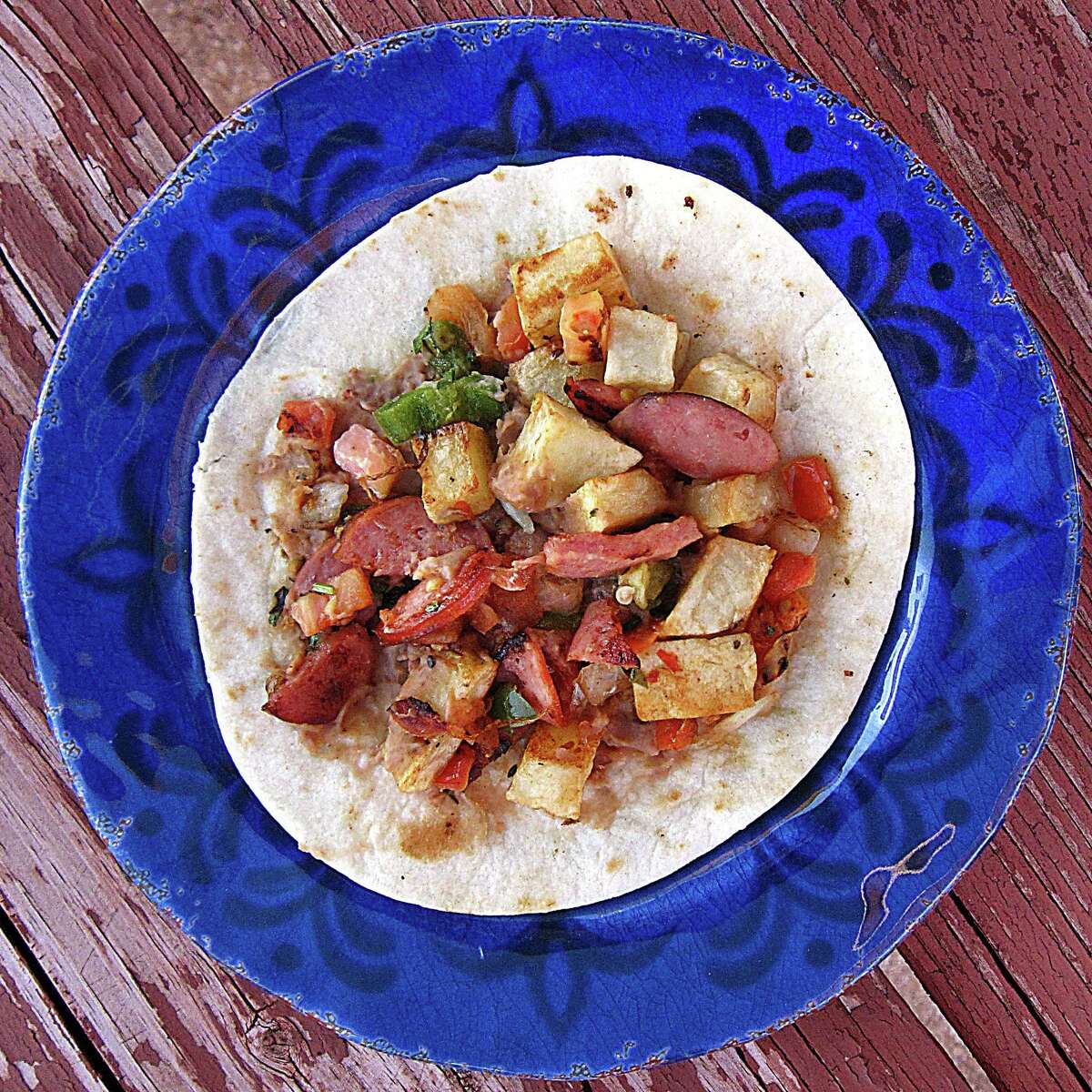 The Lalo taco with beans, country sausage, fried potatoes and pico de gallo on a handmade flour tortilla from El Toro Mexican Food.