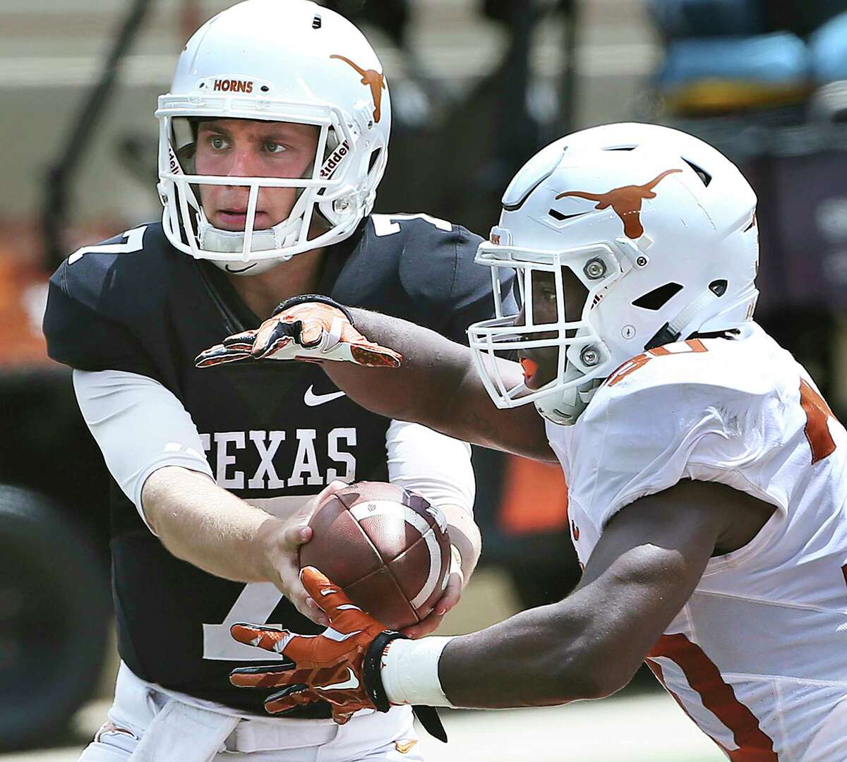 Quarterback Shane Buechele hands off to running back Toneil Carter as the Texas Longhorns play their Orange-White spring game on April 15, 2017.