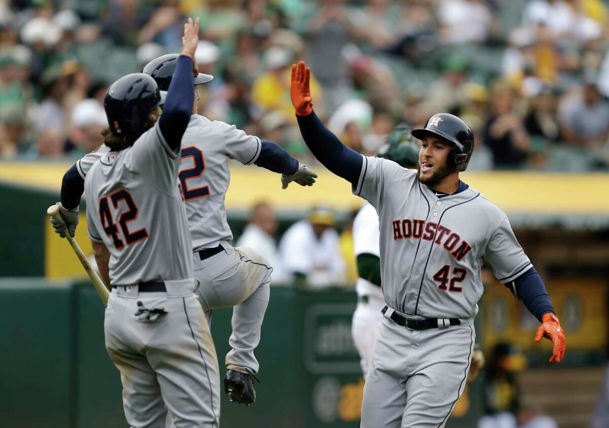 Houston Astros George Springer, right, celebrates after hitting a two-run home run off Oakland Athletics' Sean Doolittle in the eighth inning of a baseball game Saturday, April 15, 2017, in Oakland, Calif. (AP Photo/Ben Margot)