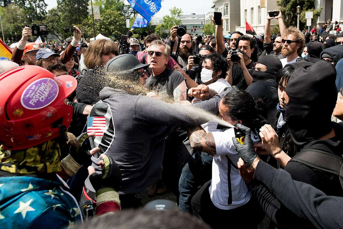 A protester against then-President Donald Trump sprays chemical irritant on a pro-Trump demonstrator on April 15, 2017. Charges of rioting stemming from this melee and two in Southern California were reinstated Thursday against members of the Rise Above Movement.