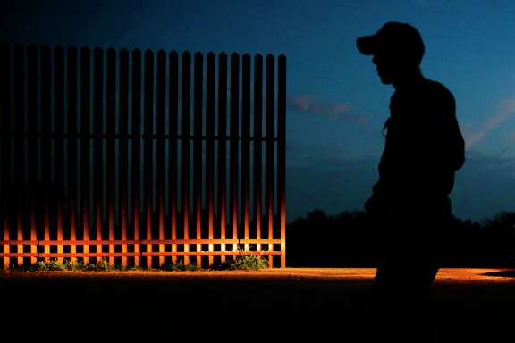A Border Patrol agent guards a gap in the border fence in Penitas, west of McAllen. The Trump administration wants to expedite the hiring of 5,000 new agents.