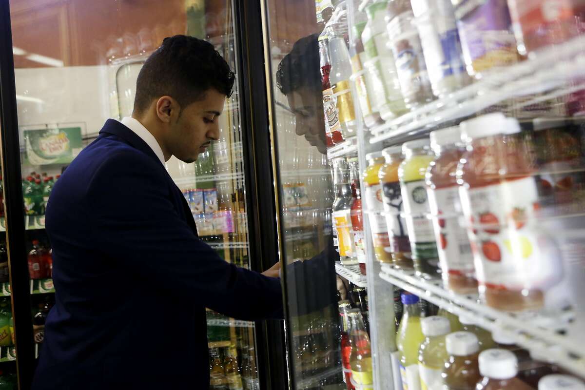 Murad Hussein, the owner of Ashby Supermarket, looks through sodas in the fridge to take inventory on Friday, April 14, 2017, in Berkeley, Calif.