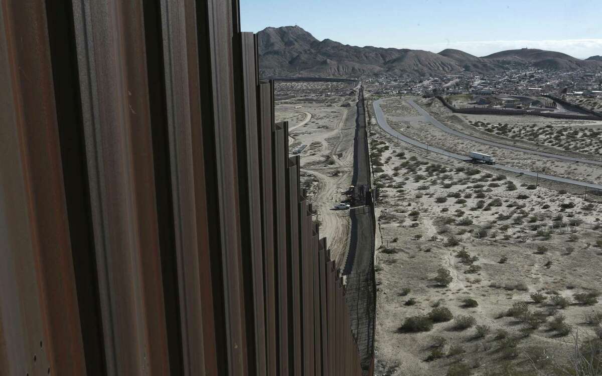FILE - This Jan. 25, 2017, file photo shows a truck driving near the Mexico-US border fence, on the Mexican side, separating the towns of Anapra, Mexico and Sunland Park, New Mexico. President Donald Trump will face many obstacles in building his ?“big, beautiful wall?” on the U.S.-Mexico border, including how to pay for it and how to contend with unfavorable geography and the legal battles ahead. (AP Photo/Christian Torres, File)