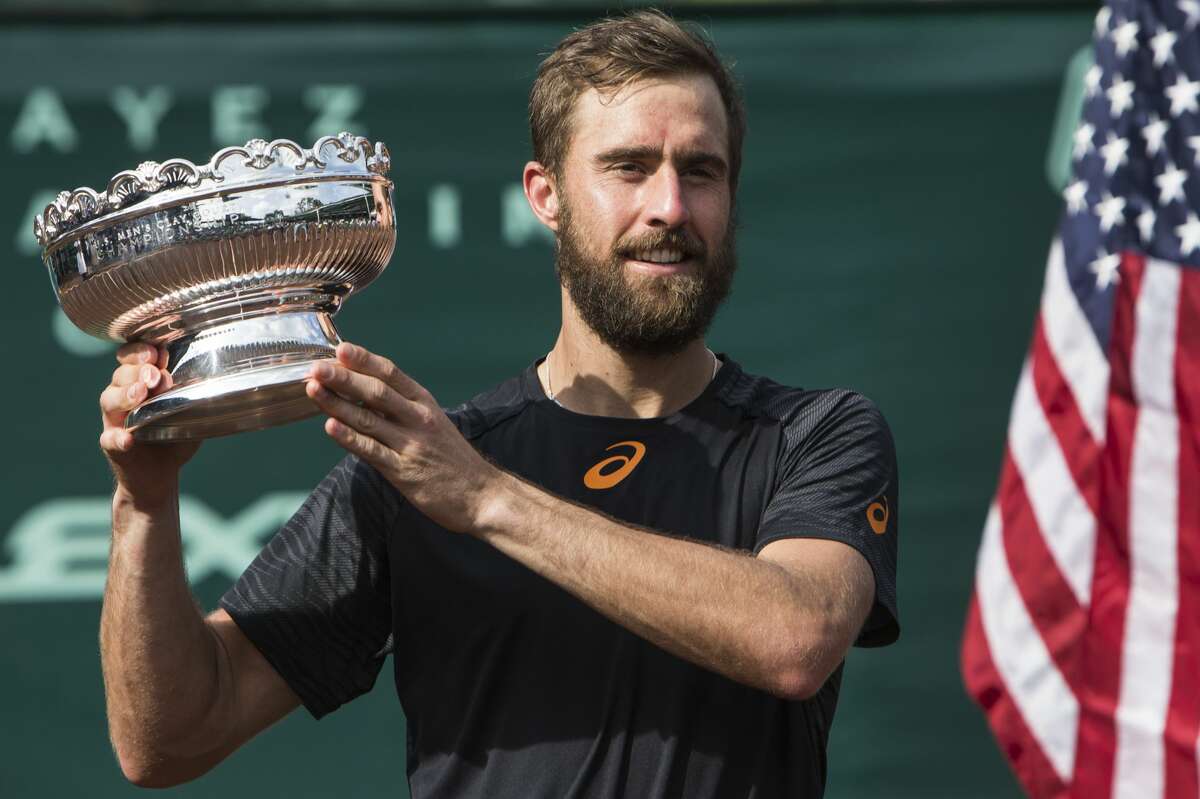 Steve Johnson shows off the championship trophy after dfeating Thomaz Bellucci in the championship singles match of the U.S. Men's Clay Court Championship tennis tournament at River Oaks Country Club on Sunday, April 16, 2017, in Houston. Johnson won 6-4, 4-6, 7-6 (5), to take the title. ( Brett Coomer/Houston Chronicle via AP)