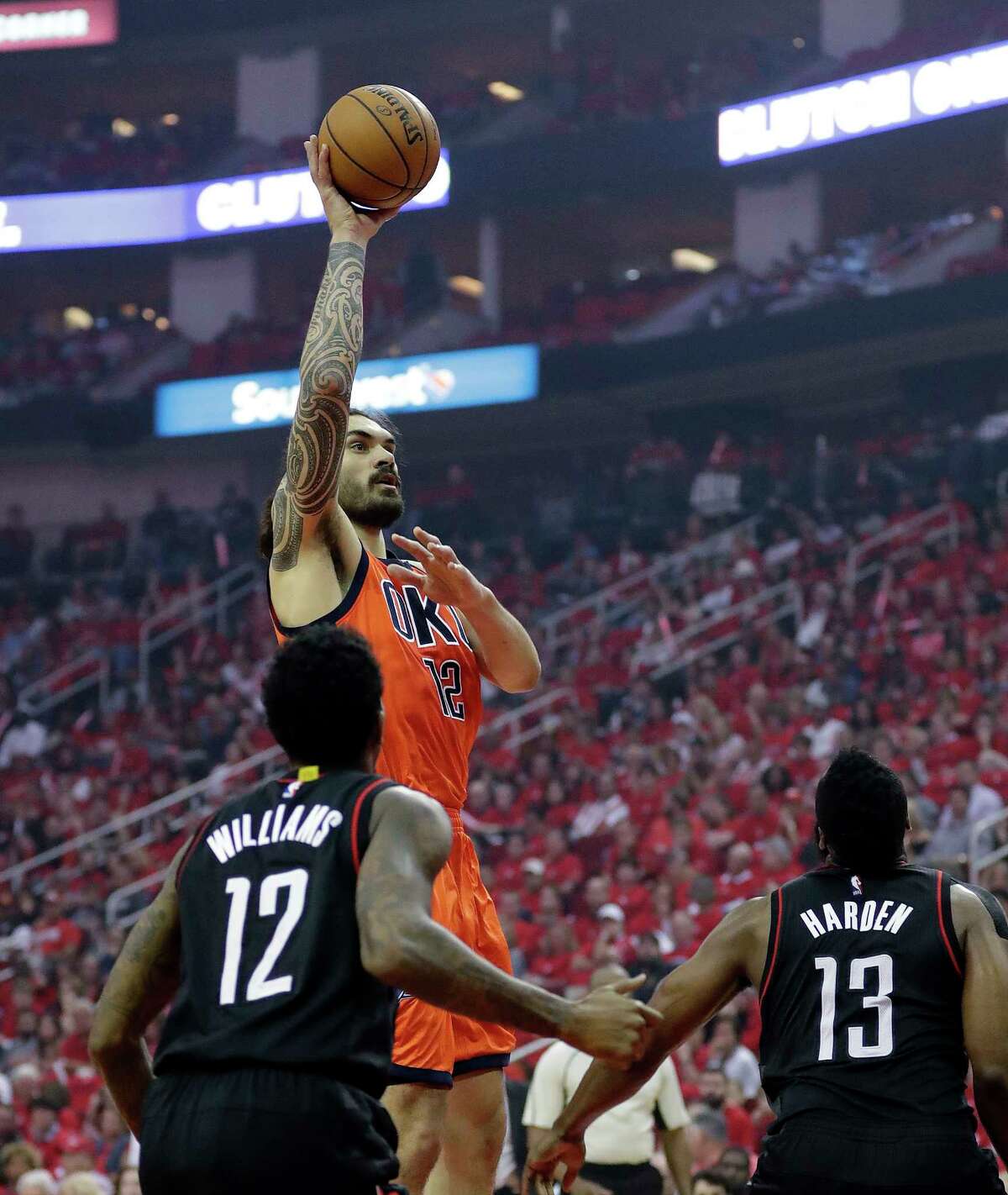 Oklahoma City Thunder's Steven Adams shoots against Houston Rockets' Lou Williams (12) and James Harden (13) during the first half of Game 1 of an NBA basketball first-round playoff series, Sunday, April 16, 2017, in Houston. (AP Photo/David J. Phillip)