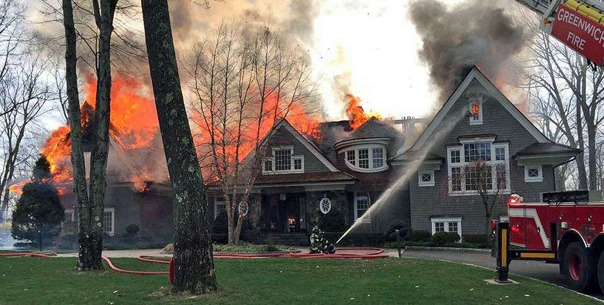 Firefighters attempt to quell a blaze on Londonderry Drive in Greenwich Sat., April 15, 2017. The cause of the fire was under investigation Monday. Officials said the distance from the closest fire hydrant, some 2000 feet, complicated the response.