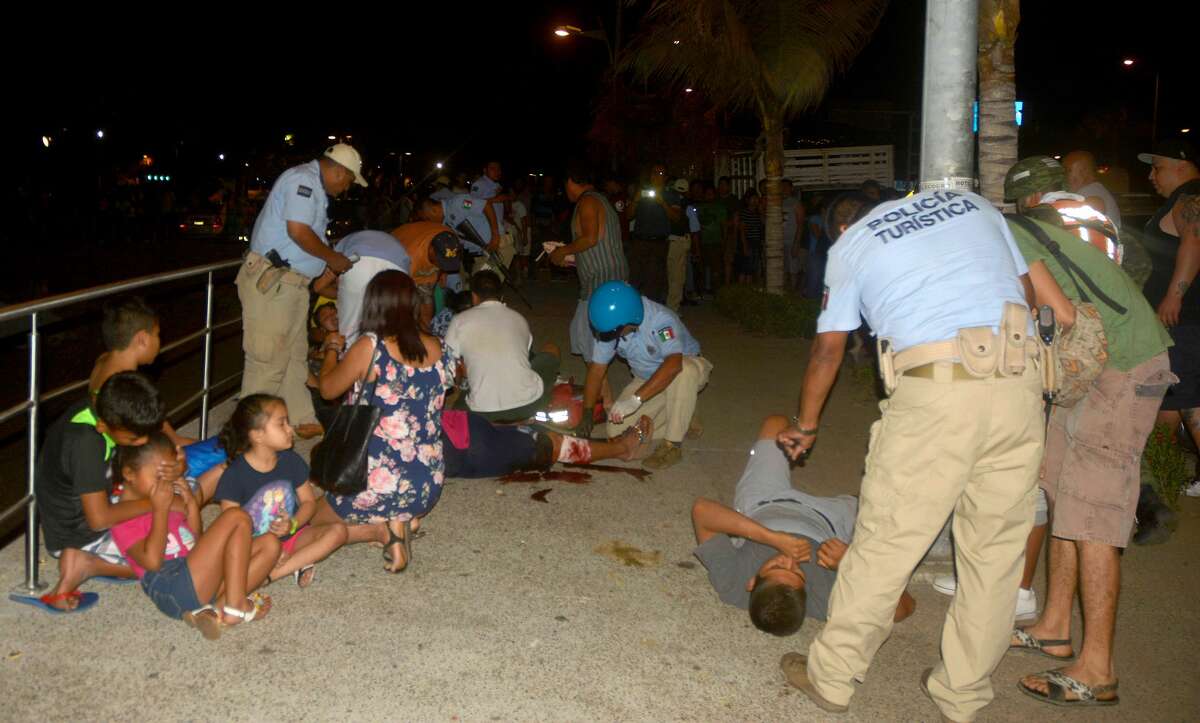 Members of Acapulco tourist police attend injured tourists after a shootout on April 15, 2017 in Acapulco, Mexico. A shootout in the tourist area of the resort left one dead and seven wounded on Saturday night, local authorities reported. / AFP PHOTO / FRANCISCO ROBLES (Photo credit should read FRANCISCO ROBLES/AFP/Getty Images)