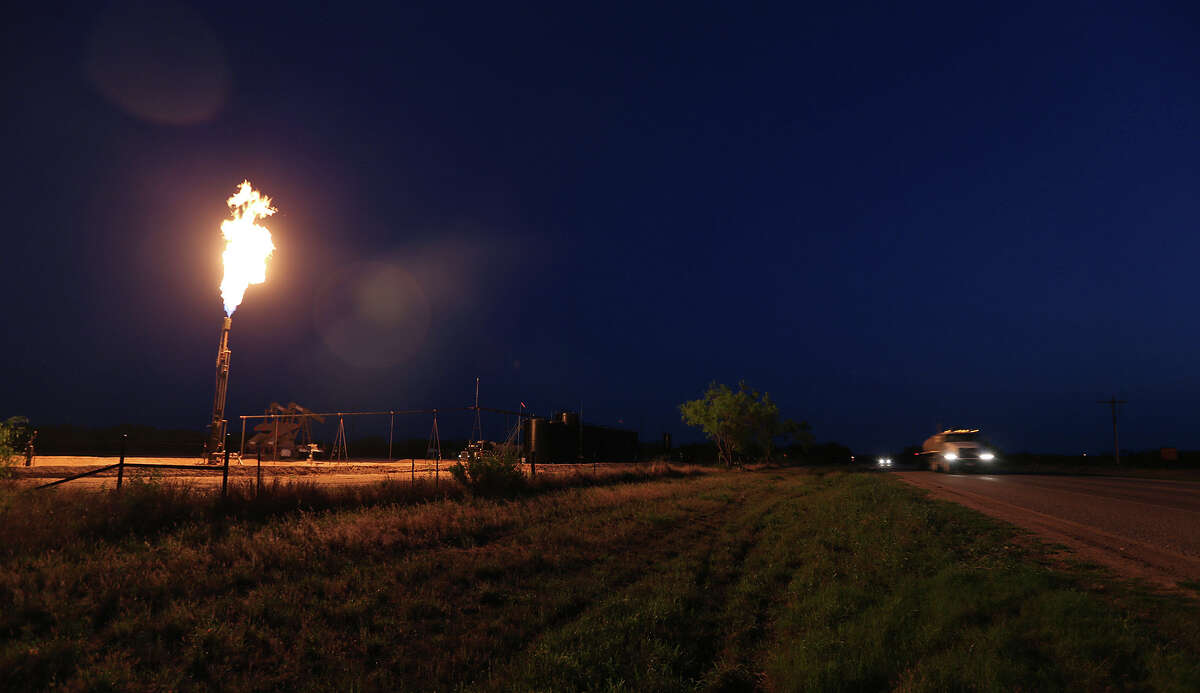 A well flares as traffic moves along Texas Highway 16 north of Tilden, Texas on Wednesday, April 2, 2014.