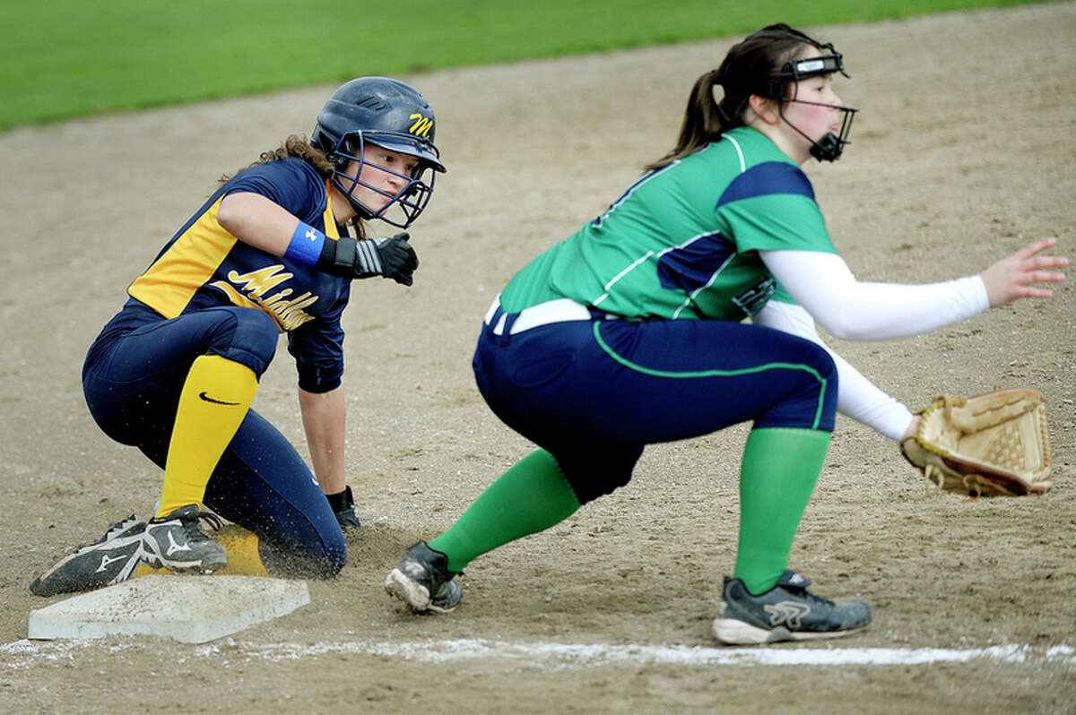 NICK KING | nking@mdn.net Midland's Julia Gross, left, slides safe at third base before Heritage's Elizabeth Newcomb-Yi can attempt a tag during the third inning on Monday at Midland High School. The Chemics won the first game of the double-header 10-0 in five innings.