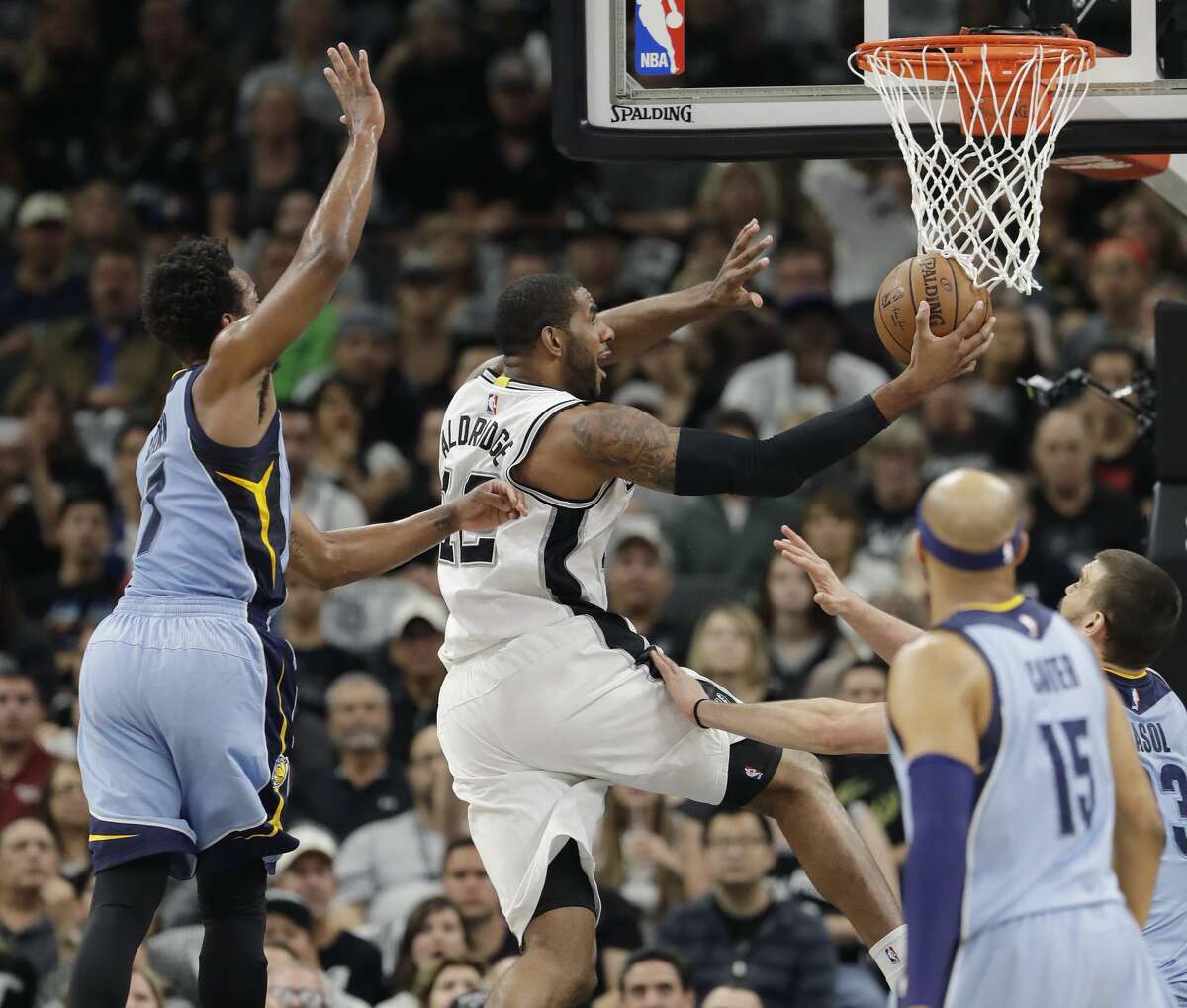 San Antonio Spurs forward LaMarcus Aldridge (12) drives past Memphis Grizzlies guard Wayne Selden (7) during the first half in Game 2 of a first-round NBA basketball playoff series, Monday, April 17, 2017, in San Antonio. (AP Photo/Eric Gay)