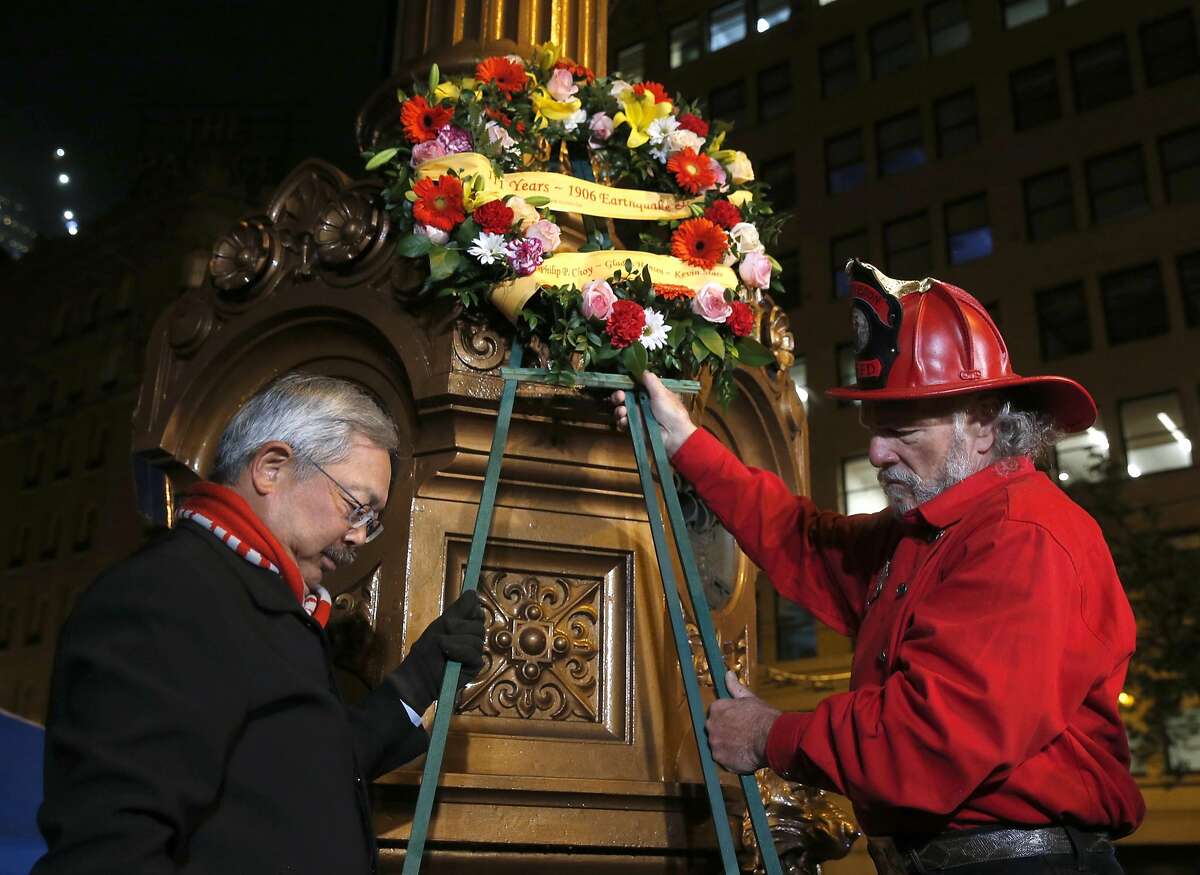 Mayor Ed Lee and John Jamieson bow their heads during a moment of silence after placing a memorial wreath on Lotta's Fountain to commemorate the 111th anniversary of the 1906 earthquake in San Francisco, Calif. on Tuesday, April 18, 2017.