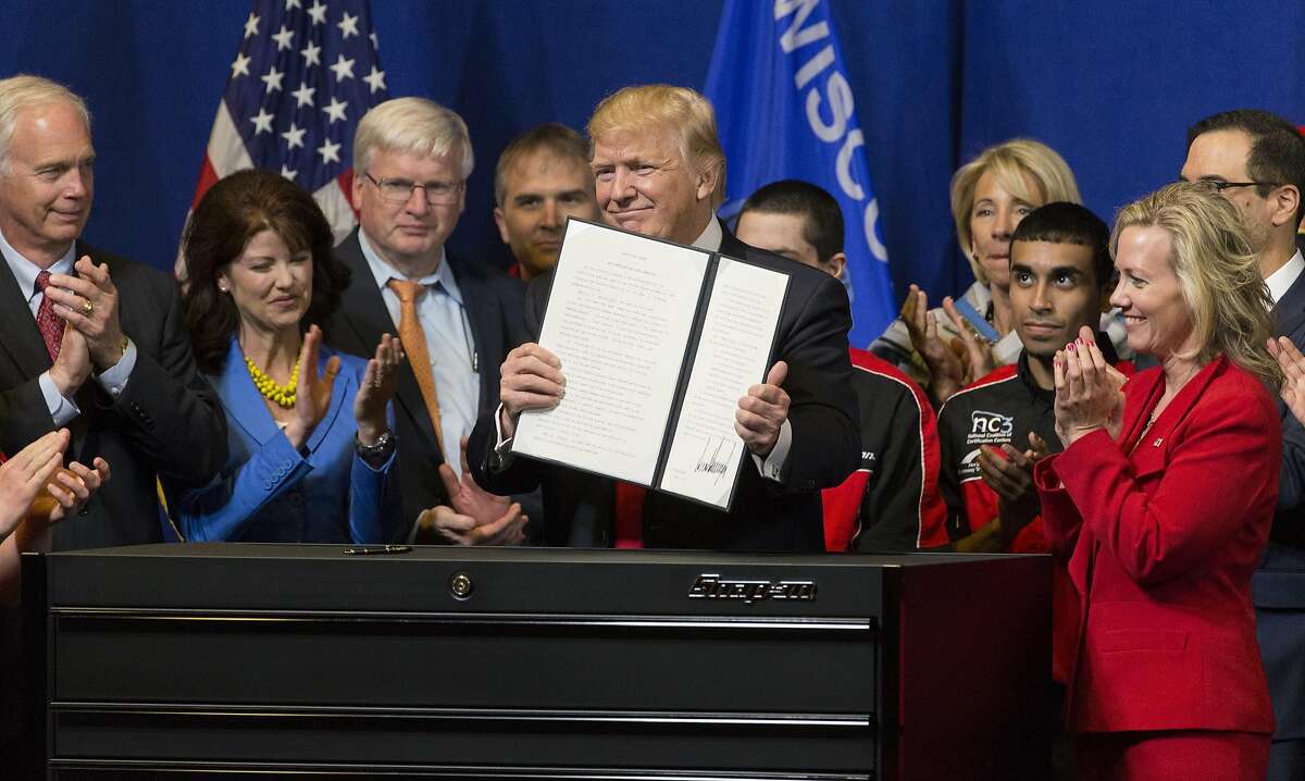President Donald Trump signs the so-called "Buy American, Hire American" executive order on Tuesday, April 18, 2017 during a visit to Snap-on Inc. in Kenosha, Wis. The orders clamp down on guest worker visas and require federal agencies to buy more goods and services from U.S. companies and workers. (Mark Hoffman/Milwaukee Journal Sentinel/TNS)