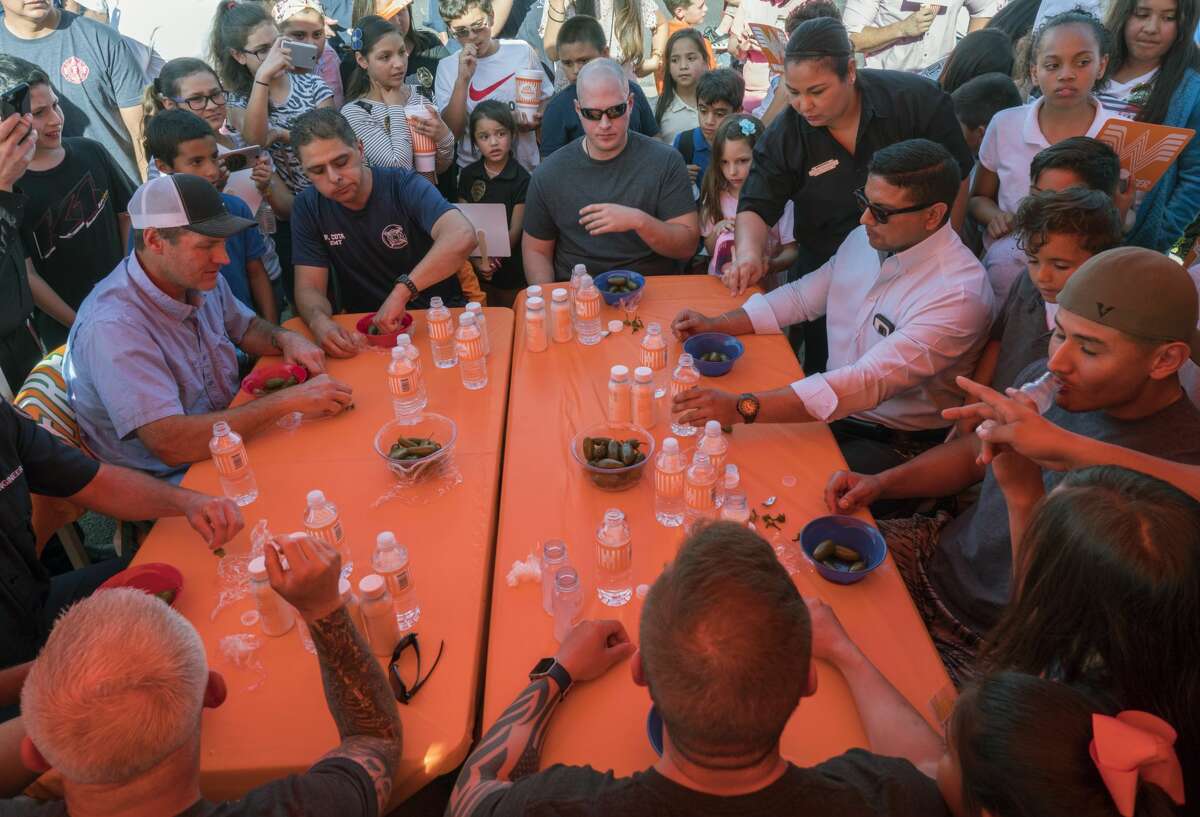 Members of the Midland Fire Department take on members of the Midland Police Department in a team event jalapeno eating contest 04-18-17 outside Whataburger on Big Spring. MPD's team ate 29 total jalapenos, earning their charity, Midland Boys and Girls Club, $1500. Tim Fischer/Reporter-Telegram
