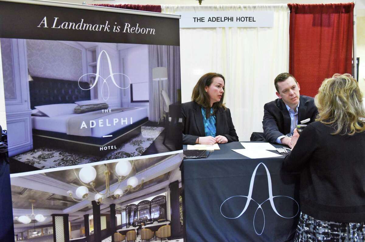 Adelphi hotel HR asst. Shannon Hubany, left, and director of housekeeping John Frazier speak a visitor to their booth during the Times Union job fair Tuesday April 18, 2017 in Colonie, NY. (John Carl D'Annibale / Times Union)