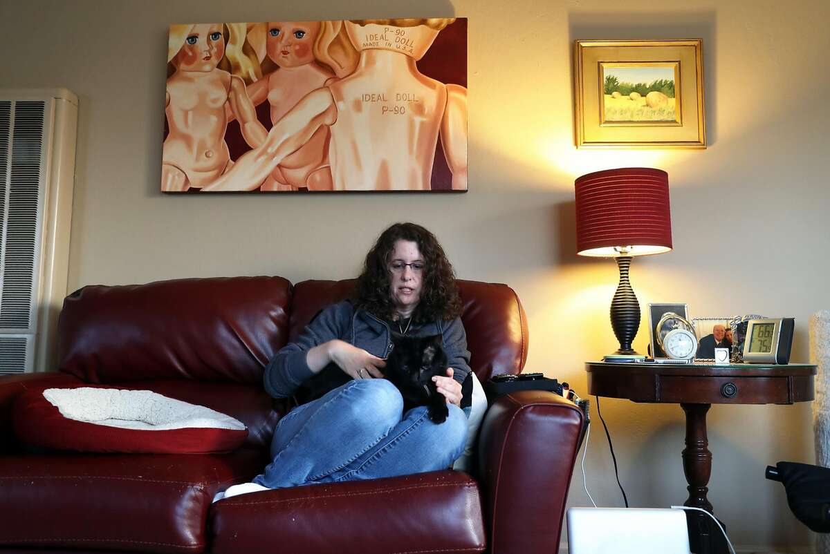 Amy Tucker relaxes with her cat, Dipper, at her apartment in Pacifica, Calif., on Tuesday, April 18, 2017. Tucker has had her rent raised $300 since April 1st.