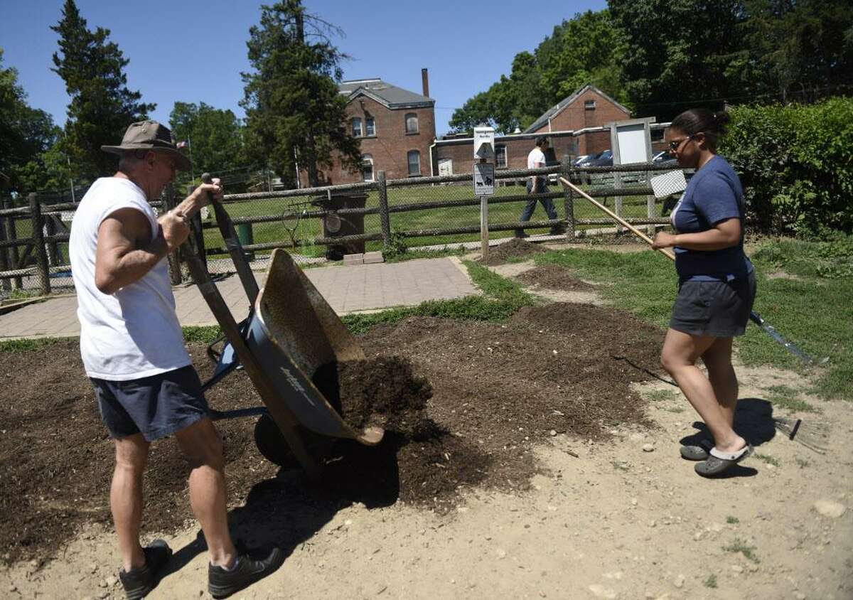 Stamford residents Herb Fordham and Malinda Long spread mulch during the 7th Birthday Celebration and Clean Up at Hunt Park in Stamford, Conn. Sunday, June 12, 2016. Volunteers from Stamford Dog Friends cleaned up and re-mulched much of Hunt Park, the city's sole municipal off-leash dog park.
