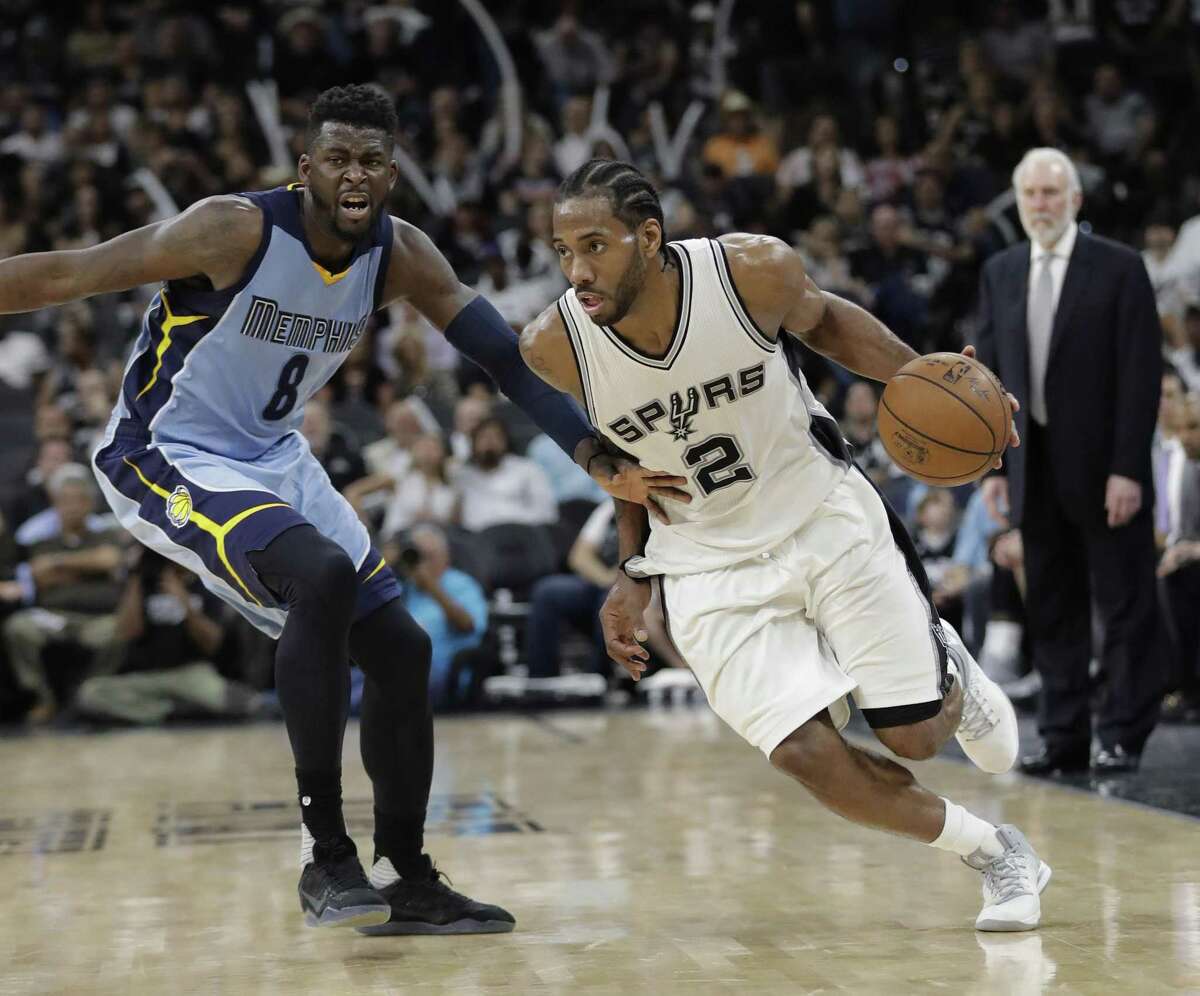 Spurs forward Kawhi Leonard drives around Memphis Grizzlies forward James Ennis III during the second half in Game 2 on April 17, 2017, in San Antonio. San Antonio won 96-82.