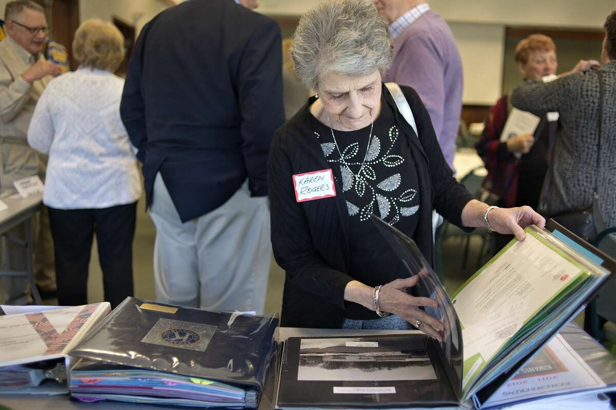 BRITTNEY LOHMILLER | blohmiller@mdn.net Karen Rogers of Midland flips through old scrapbooks made by former Kiwassee Kiwanis of Midland presidents during the 50th anniversary celebration at Trinity Lutheran Church Tuesday afternoon. The Kiwassee Kiwanis was started in 1967.