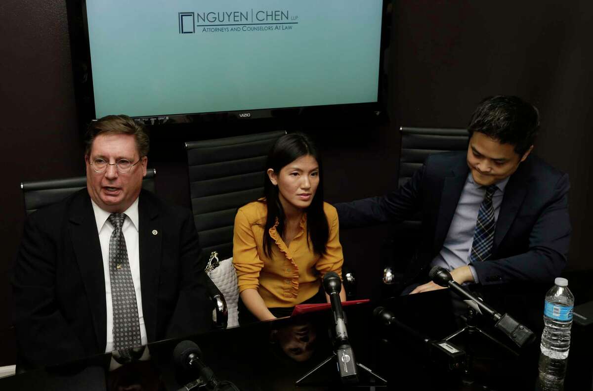 Attorneys David Armbruster, left, and Brian Nguyen, right, are shown with their client Tu Thien Huynh, center, at a media conference Wednesday, April 19, 2017, in Houston. She had been charged with murdering her husband, Steven Hafer, but the Harris County District Attorney's office announced that charges have been dropped and her husband's death has been ruled a suicide.