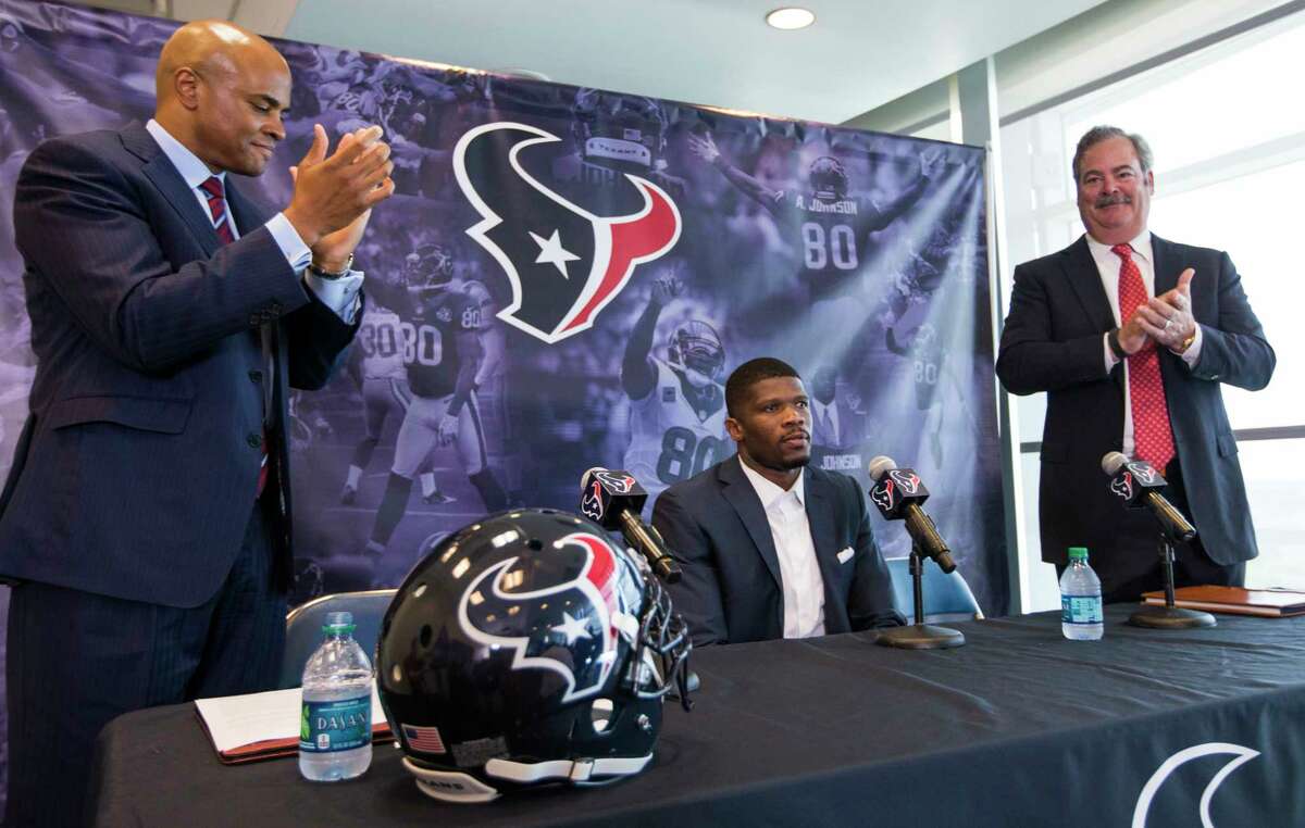 Houston Texans general manager Rick Smith, left, and Texans chief operating officer Cal McNair, right, give a standing ovation to former Texans wide receiver Andre Johnson during a retirement ceremony for Johnson at NRG Stadium on Wednesday, April 19, 2017, in Houston. Johnson signed a one-day contract to retire as a Texans player. ( Brett Coomer/Houston Chronicle via AP)