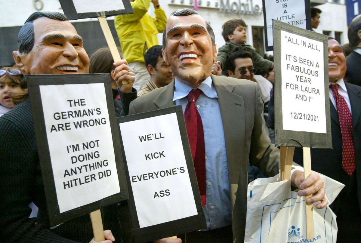 Protesters dressed as George Bush carry signs during an anti-war rally January 18, 2003 in San Francisco. Over 100,000 people marched through the streets of San Francisco in protest of a war against Iraq.