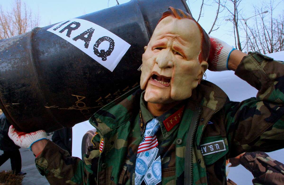 Wearing a mask representing U.S. President George W. Bush, a South Korean protester holds an oil barrel at an anti-war rally near the U.S. embassy February 14, 2003 in Seoul, South Korea.