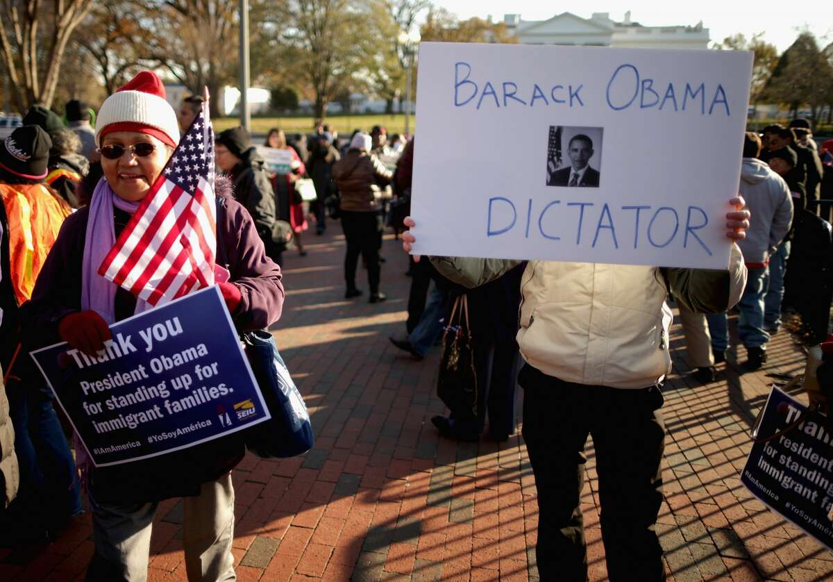 An anti-immigration demonstrator moves among about 100 people who have gathered to rally in support of President Barack Obama's executive action on immigration policy in Lafayette Square across from the White House November 21, 2014 in Washington, DC.