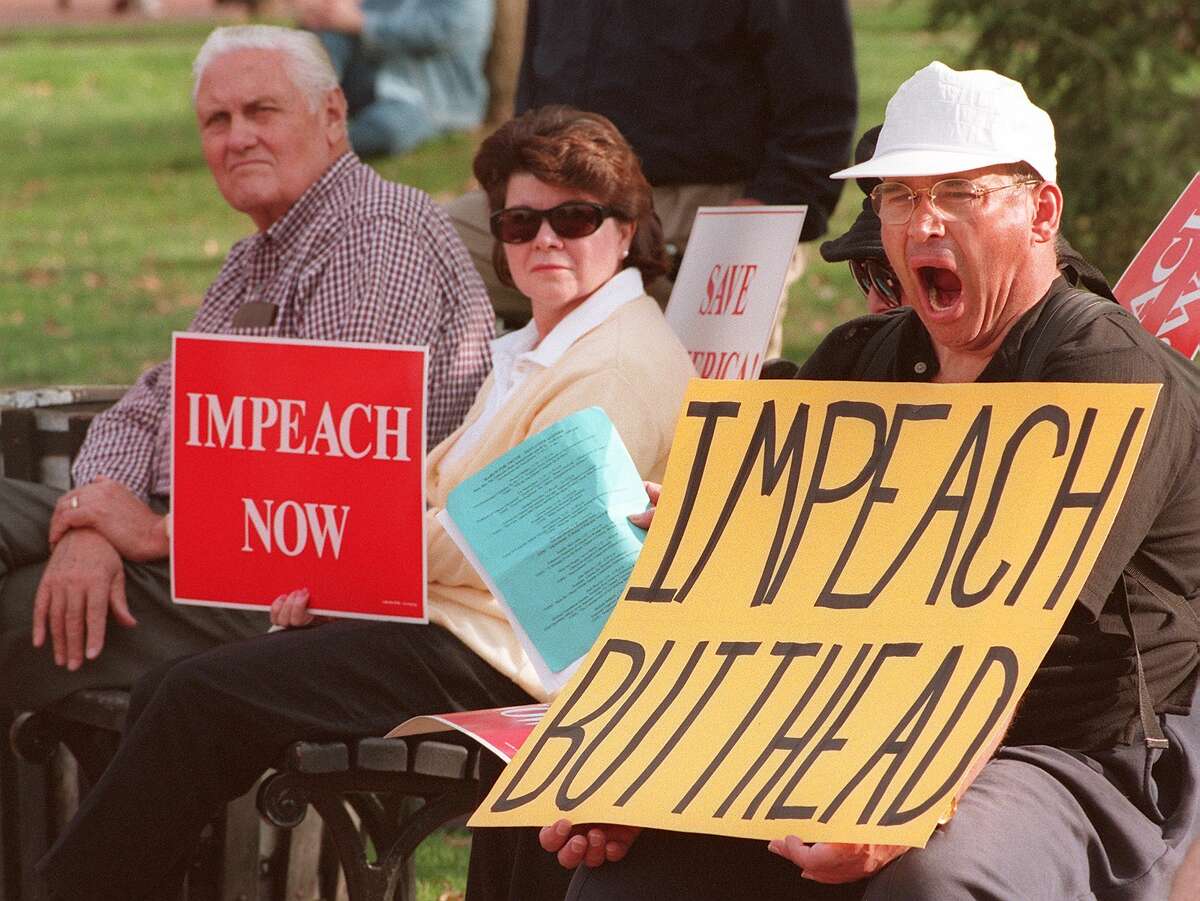 Unidentified protesters demanding the impeachment of President Bill Clinton conduct their noontime protest from the park benches in Lafayette Park across from the White House. Clinton's lawyers "will present a case that is robust" in up to 30 hours of hearings Tuesday and Wednesday before the House Judiciary committee on Capitol Hill.