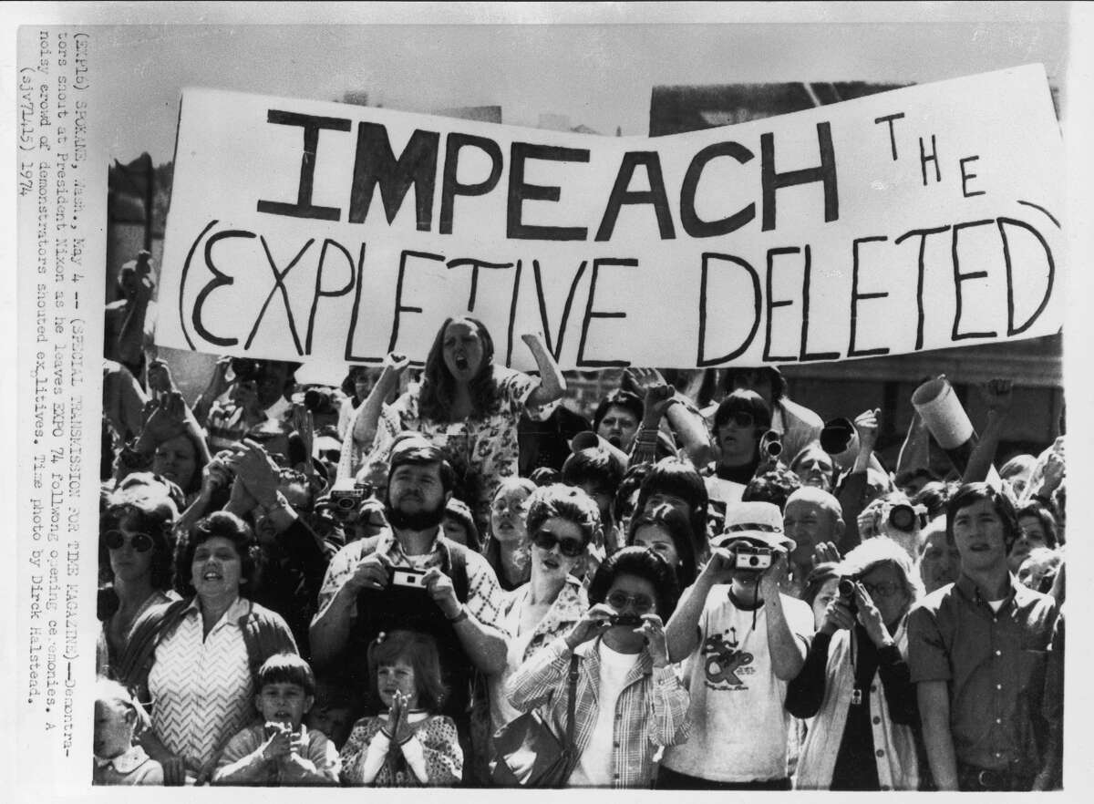 Demonstrators with sign saying "IMPEACH THE (EXPLETIVE DELETED)" shout at President Nixon as he leaves EXPO 74 following opening ceremonies.