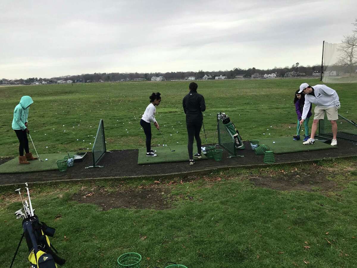 Participants at an April 12, 2017 Golf to Give clinic at Longshore Golf Course hit golf balls on the driving range.