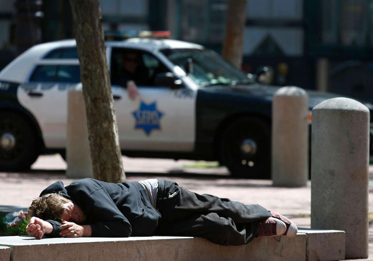 Police patrol at the edge of San Francisco’s drug-riddled Tenderloin neighborhood at United Nations Plaza where a man is lying down. Drug overdoses have soared in the area especially during the past two years as fentanyl has become the opioid of choice.