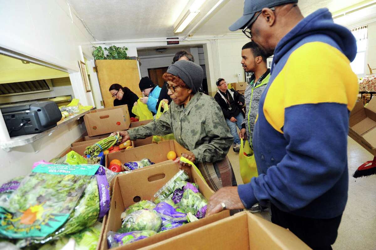 Mother Louise Montgomery, 92, grabs a bundle of asparagus to load into a bag at the Wilson Memorial Church in Stamford.