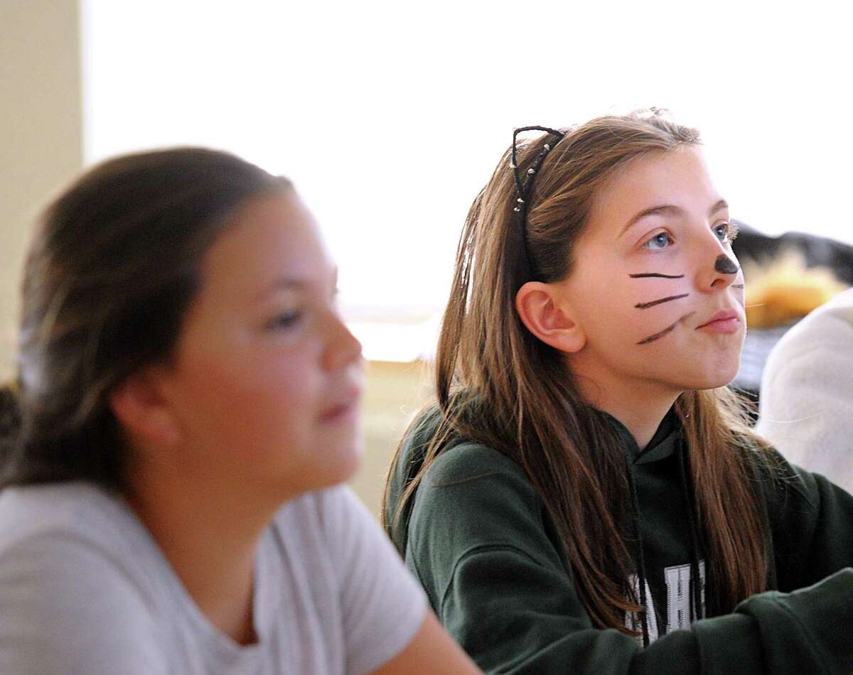Sixth grade student Constanza Meyerhoff, 12, right, wore a cat costume to school as part of Earth Day activities at Sacred Heart Greenwich, Conn., Wednesday, April 19, 2017. Middle school students made a $3.00 donation for the privilege of wearing an animal costume to school and not having to wear their school uniform for the day. The money raised by the students was donated toward a clean water campaign for a Sacred Heart sister school in Uganda that they support.