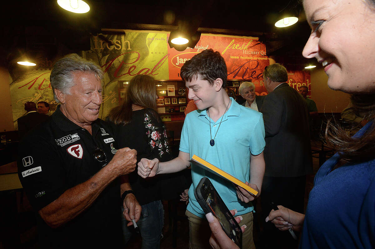 Famous race car driver Mario Andretti gives a fist bump to fan Nate Graham as his mother Amy looks on as he makes his way in during a meet and greet rally at Jason's Deli in the Gateway Plaza Thursday. The event was the first social stop for Andretti, who was the celebrity host at this year's Champagne and Ribs fundraising gala Thursday night. Photo taken Thursday, April 20, 2017 Kim Brent/The Enterprise