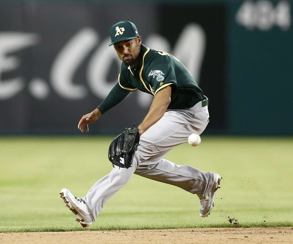 Oakland Athletics shortstop Marcus Semien prepares to field a grounder by Texas Rangers' Mike Napoli, who was out at first during the sixth inning of a baseball game, Friday, April 7, 2017, in Arlington, Texas. (AP Photo/Jim Cowsert)