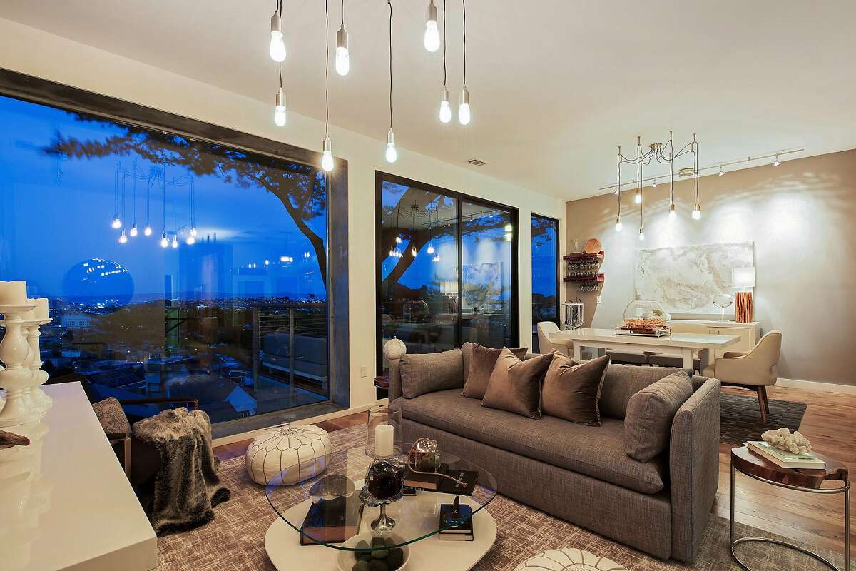 The living room boasts hardwood flooring and floor-to-ceiling windows.