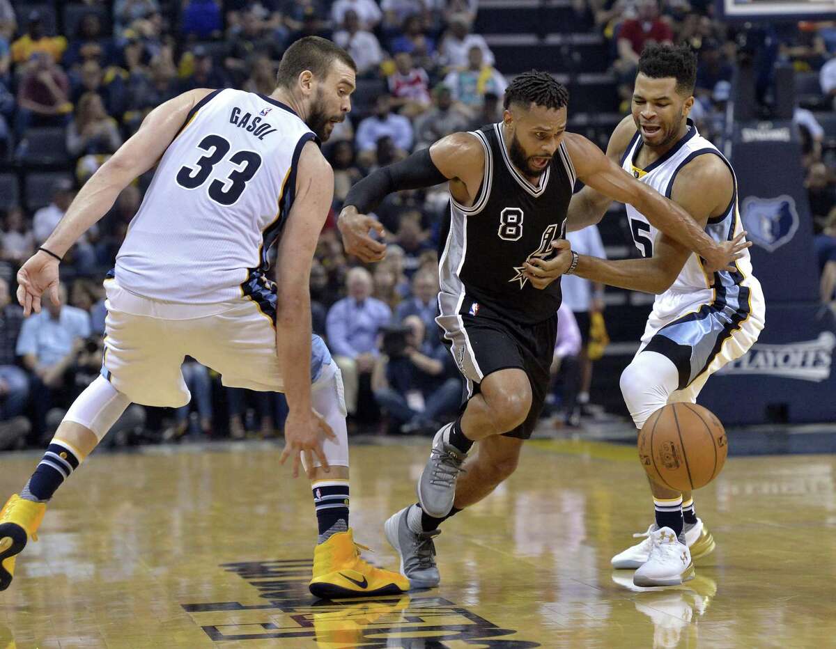 San Antonio Spurs guard Patty Mills (8) loses control of the ball while driving between Memphis Grizzlies center Marc Gasol (33) and guard Andrew Harrison (5) during the second half of Game 3 in an NBA basketball first-round playoff series Thursday, April 20, 2017, in Memphis, Tenn. (AP Photo/Brandon Dill)