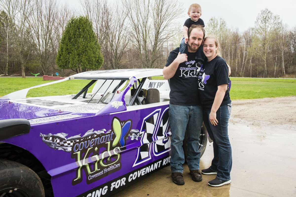 DANIELLE McGREW TENBUSCH | for the Daily News Brent and Jennifer Reil pose for a photo with their son Brantley Reil in front of their race car. The couple is selling shirts and raffle tickets to raise money for Covenant Kids, as well as raising awareness with the car's body design. ?’All the proceeds are going to Covenant Kids,?“ Brent Reil said. ?’There?•s a lot of people that race, so we want to show the racing family to what Covenant?•s all about. We?•re really trying to give them a big check.?“
