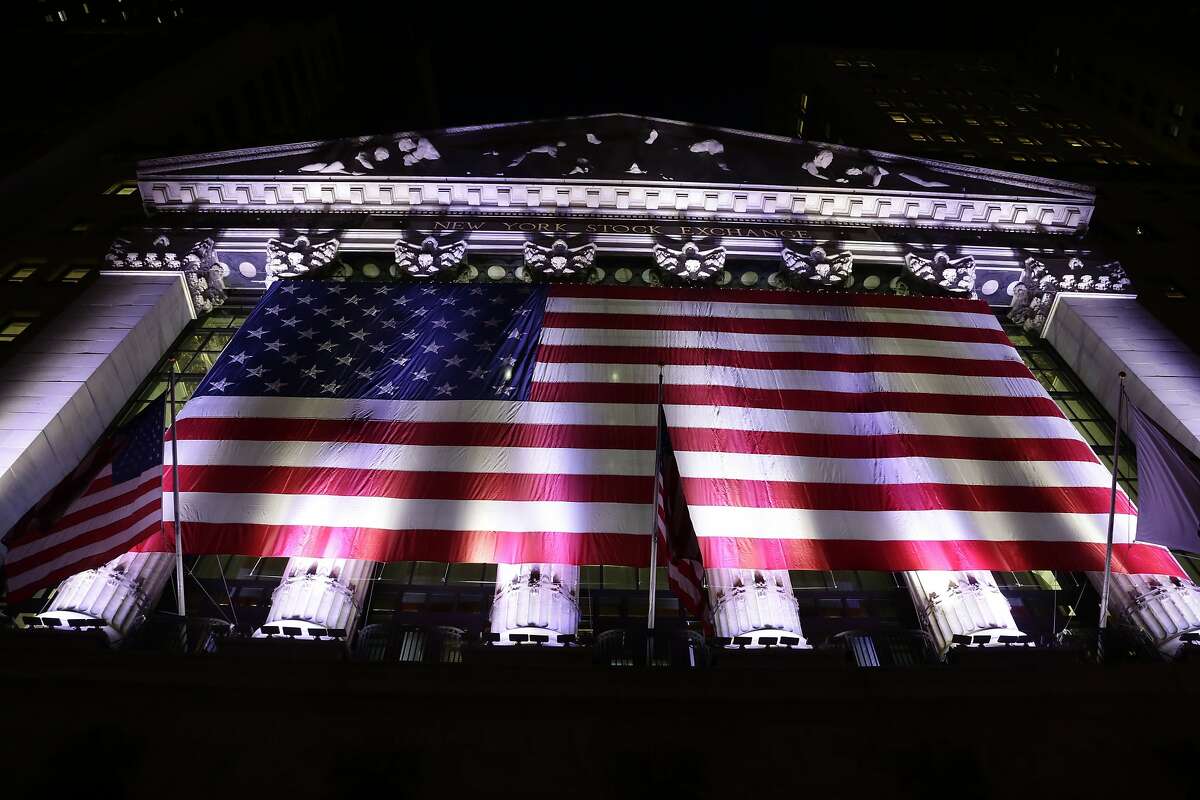 In this evening Friday, Feb. 17, 2017, photo, an American flag hangs on the front of the New York Stock Exchange. European stocks declined while most Asian markets rose Friday, April 21, 2017, ahead of the first round of voting in France's closely watched presidential election. (AP Photo/Peter Morgan)