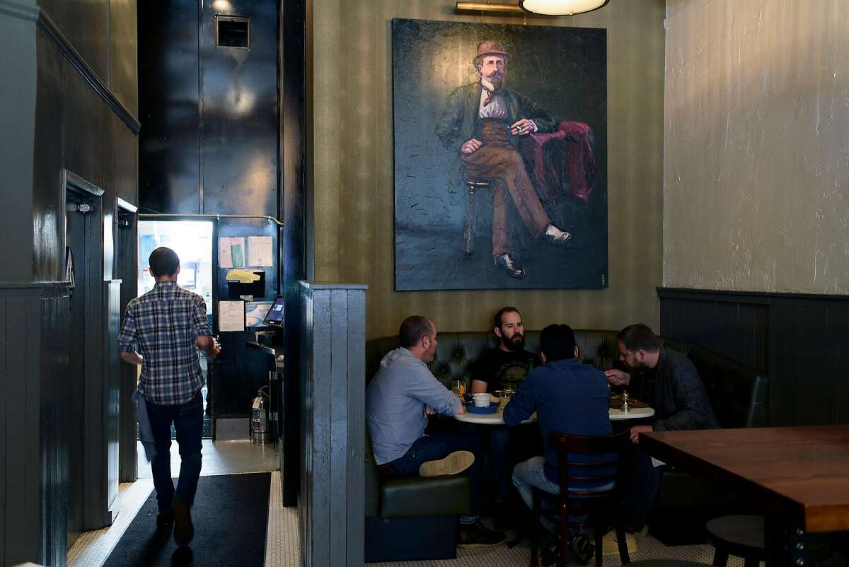 Customers sit under a painting of "Lord George" as bartender Markus Reinhard walks into the kitchen at the restaurant Lord George in San Francisco, CA, on Friday April 21, 2017.