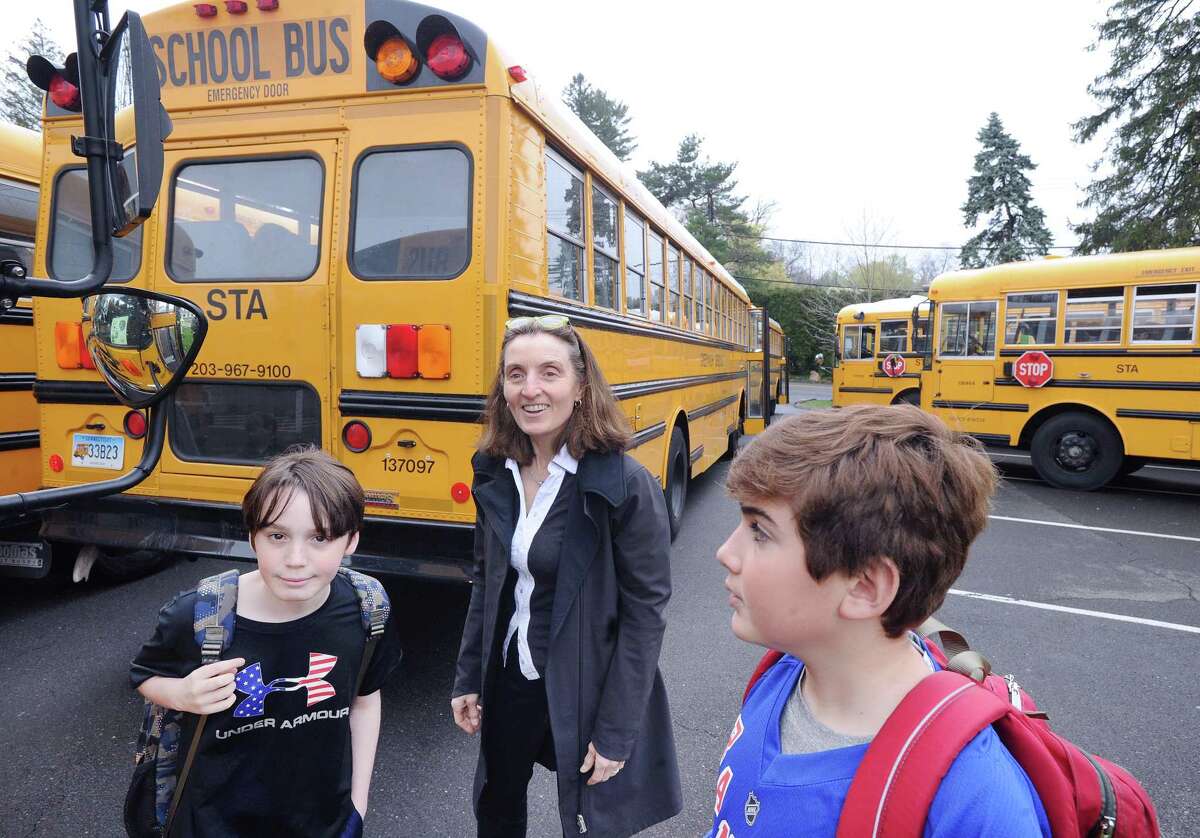 Greenwich Country Day School Sustainability Director Laura di Bonaventura, center, helps students participating in "Tiger Rides" find their school buses at Greenwich Country Day School in Greenwich, Conn., Friday, April 21, 2017. Tiger Rides is a Greenwich Country Day School program designed to encourage bus riding and carpooling for a better environment.