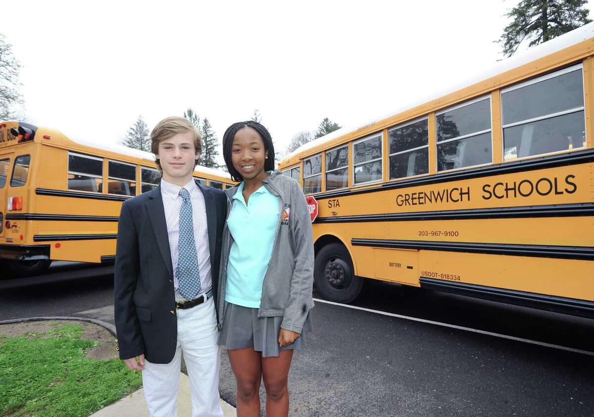 Greenwich Country Day School 9th grade students, Jack Vanneck, 15, left, and Jordan Mitchell, also 15, who were instrumental in helping to develop "Tiger Rides," an Earth Day inspired program designed to encourage bus riding and carpooling for a better environment, stand by school buses at Greenwich Country Day School in Greenwich, Conn., Friday, April 21, 2017. Greenwich Country Day School Sustainability Director Laura di Bonaventura said that 90 GCDS students are participating in the program by riding the town school buses and that 200 GCDS students are carpooling participants.
