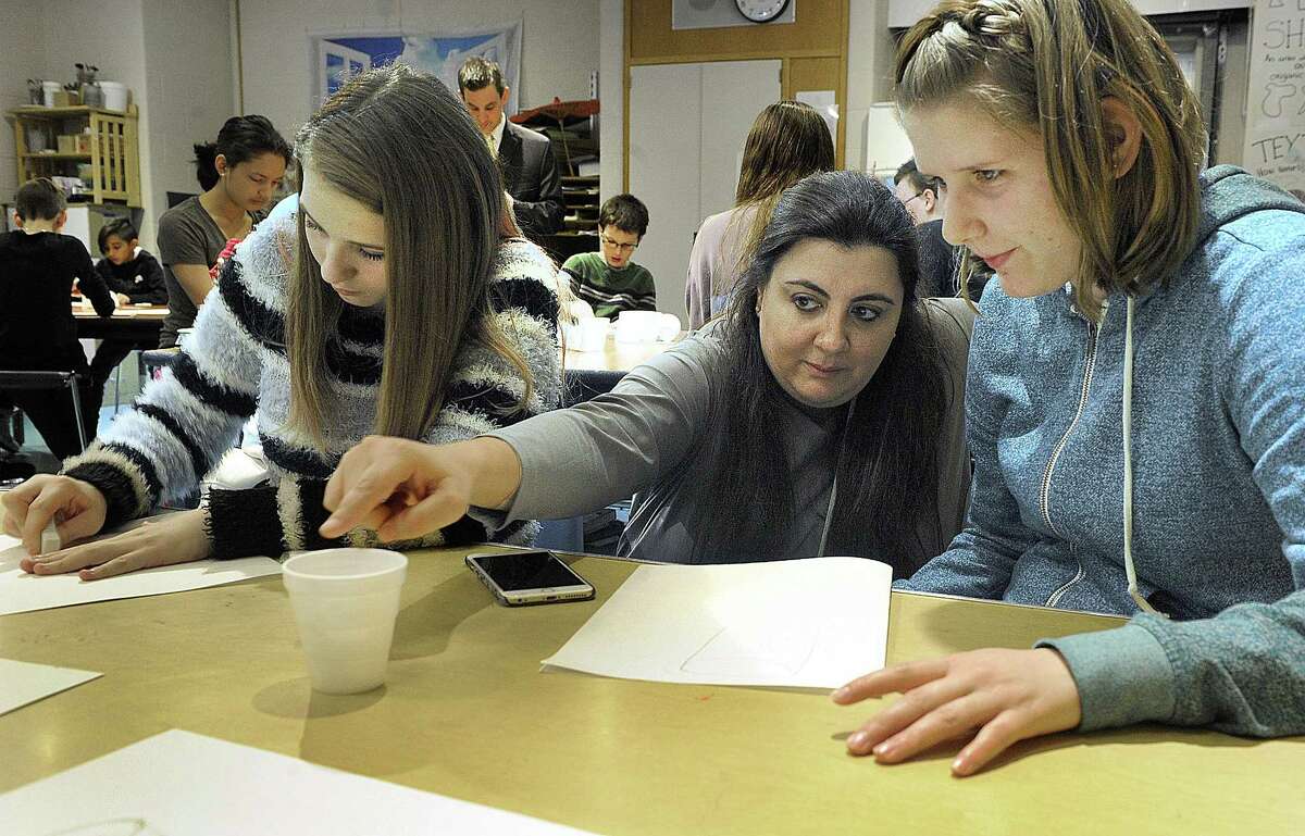 At right, Art teacher Layla Kateurji, of Lebanon, visiting Schaghticoke Middle School in New Milford, talks to Gina Galligan about drawing 3-D objects. Left is Caitlin Rakowski, working on the same assignment.