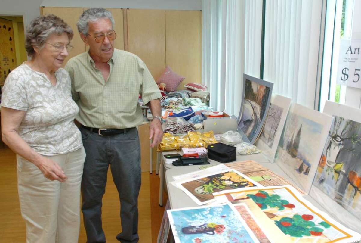 Ellie Preisig, left, and Carl Tomanio prepare for a tag sale at Elmwood Hall, Danbury Senior Center, Thursday, June 3, 2010.