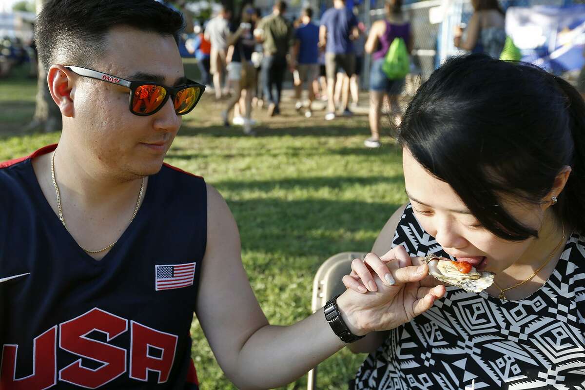 Richard Holtrop and Sherlyn Gan enjoy baked oysters during the 2017 Fiesta Oyster Bake held Friday April 21, 2017 on the St. Mary?•s University campus.
